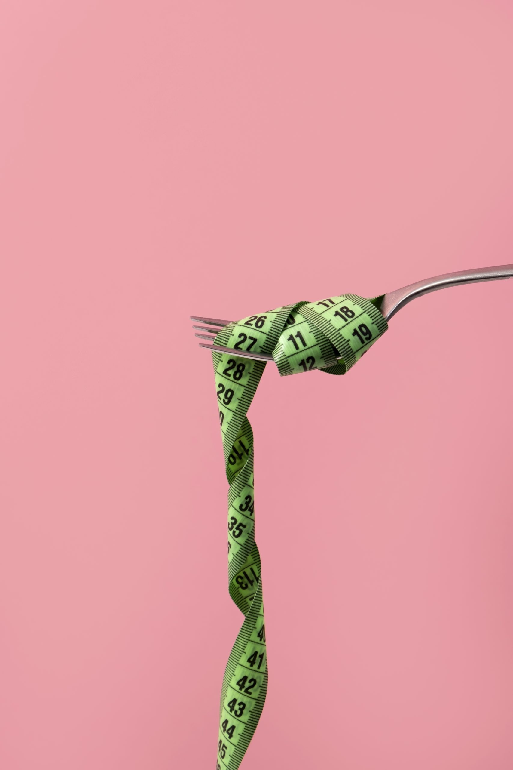 Mide küçültme sonrası beslenmeyi simgeleyen, çatalın ucuna sarılı mezura görseli.