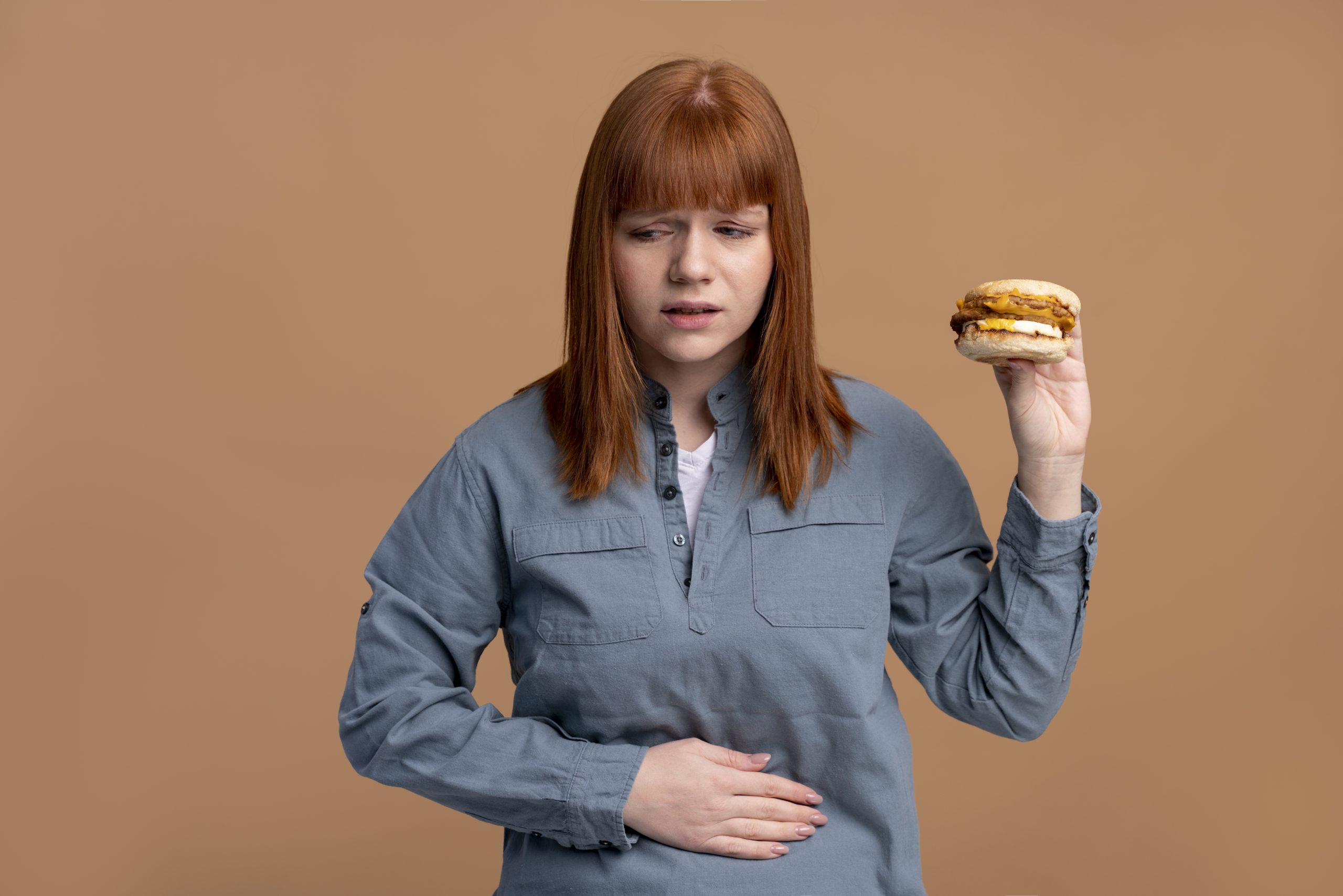 Mide ameliyatı sonrası yemek listesi konusunda kararsız kalan kadın, sağlıksız yiyecek tercihleri nedeniyle mide rahatsızlığı yaşayan kişi