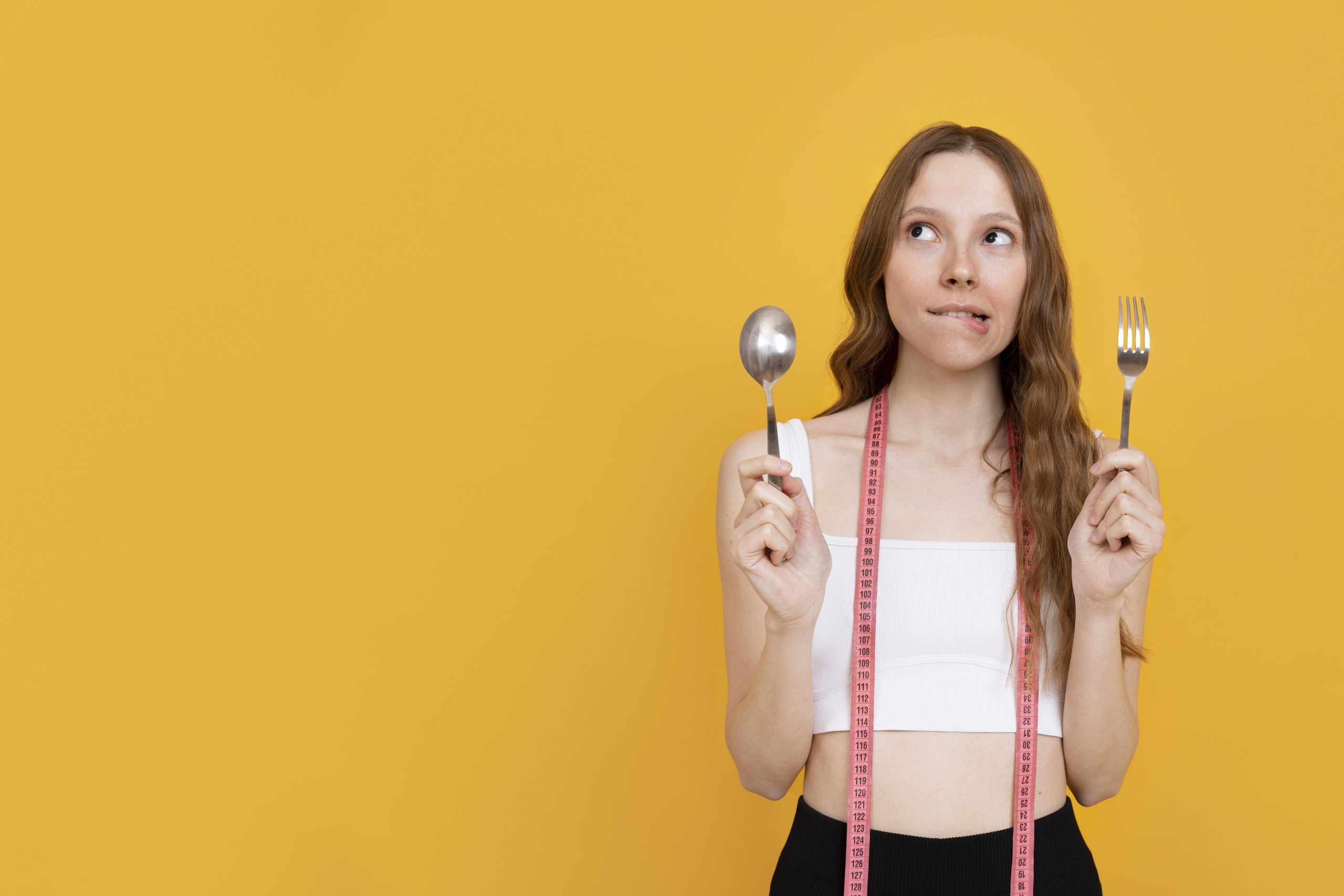 Mide küçültme sonrası yavaş yemek alışkanlığını temsil eden, çatal ve kaşık tutan genç kadın görseli.